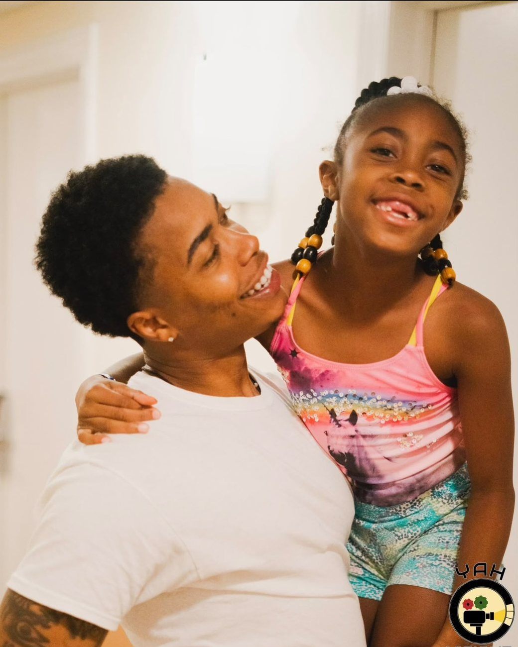 Brandon laughing with his daughter in his arms