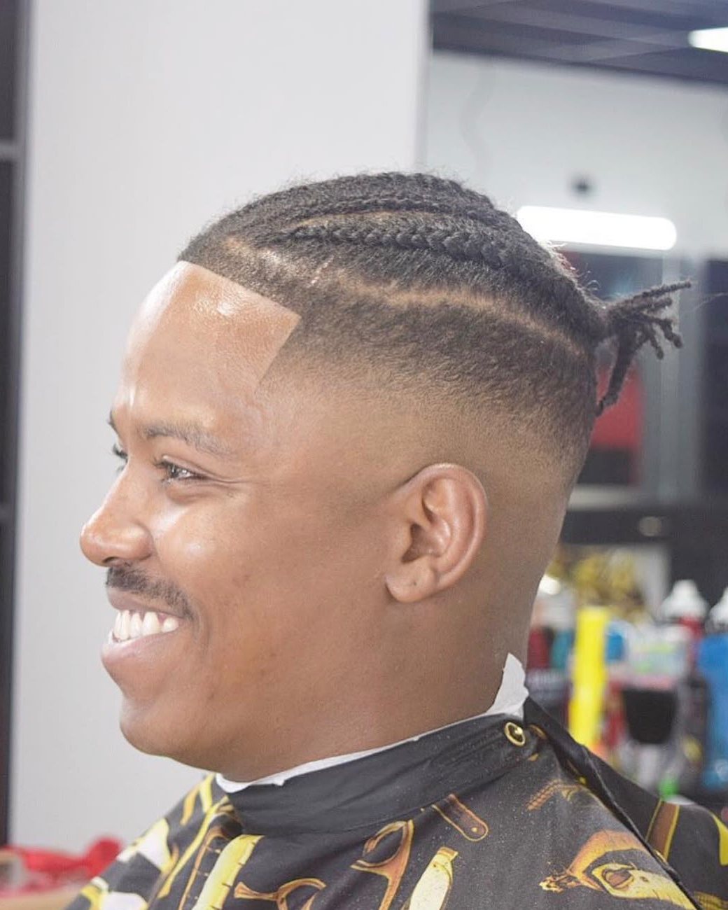 Braids with a high skin fade and razor part