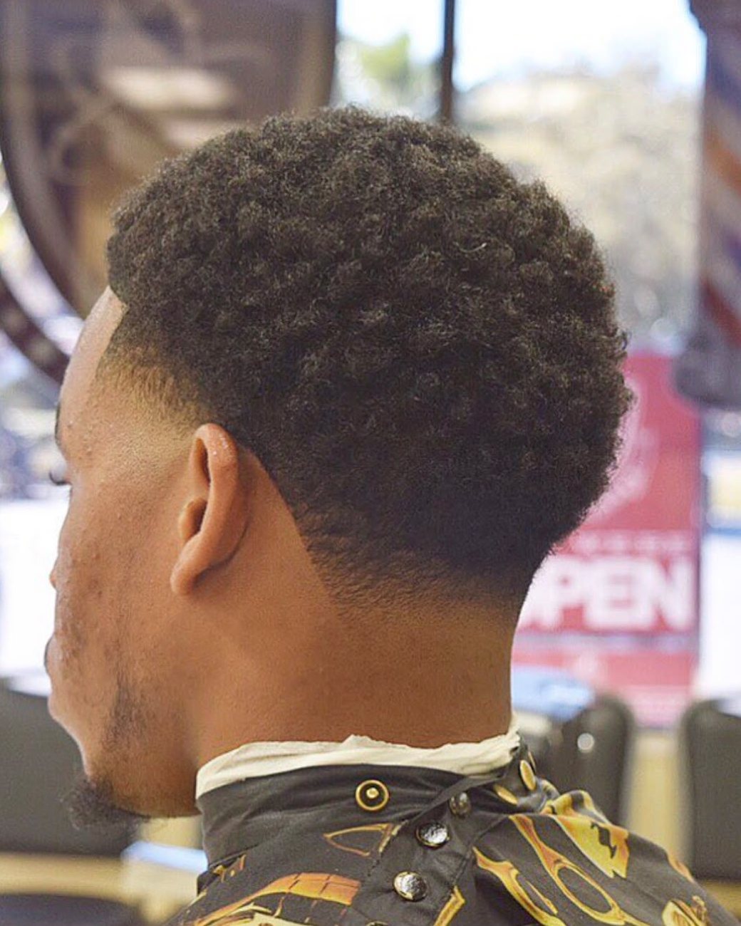 Curly top with a clean taper and sharp neckline