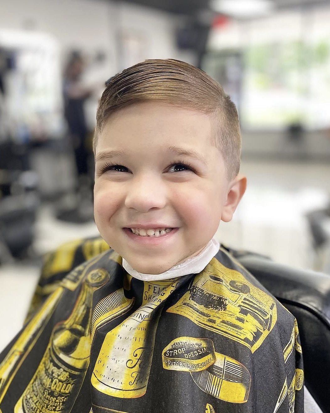Smiling young client with a fresh side-part and taper