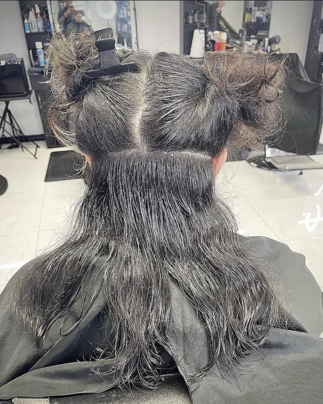Mid-cut: hair sectioned and clipped for a precise ladies' trim