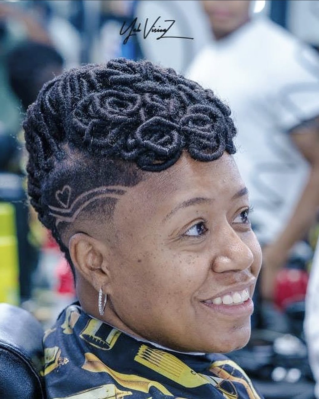 Smiling client with sculpted locs, a taper and a heart design