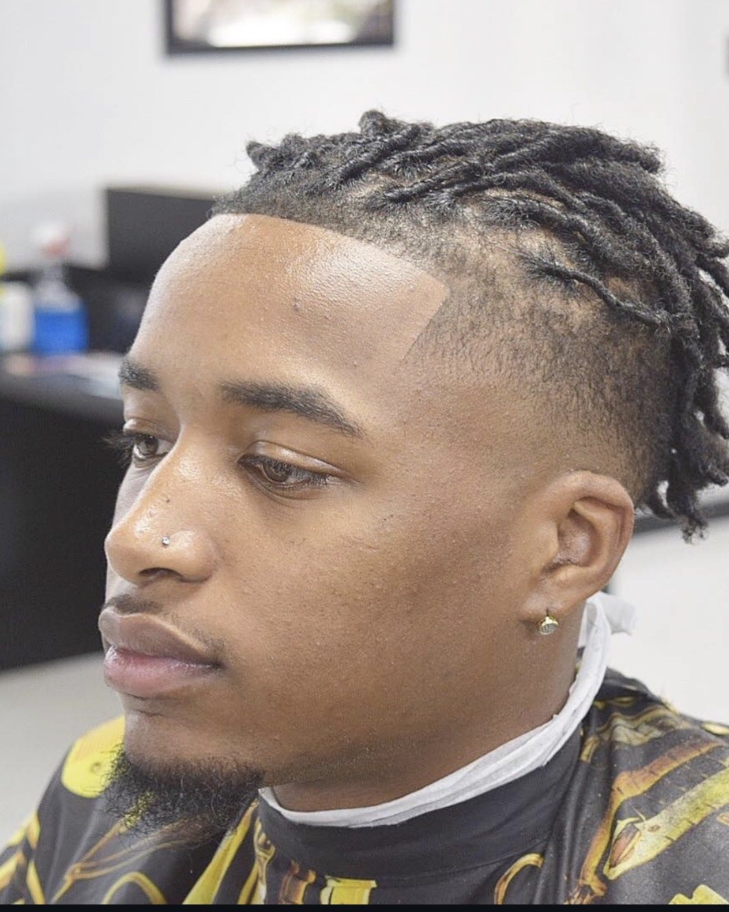 Starter locs with a sharp line-up and temple fade