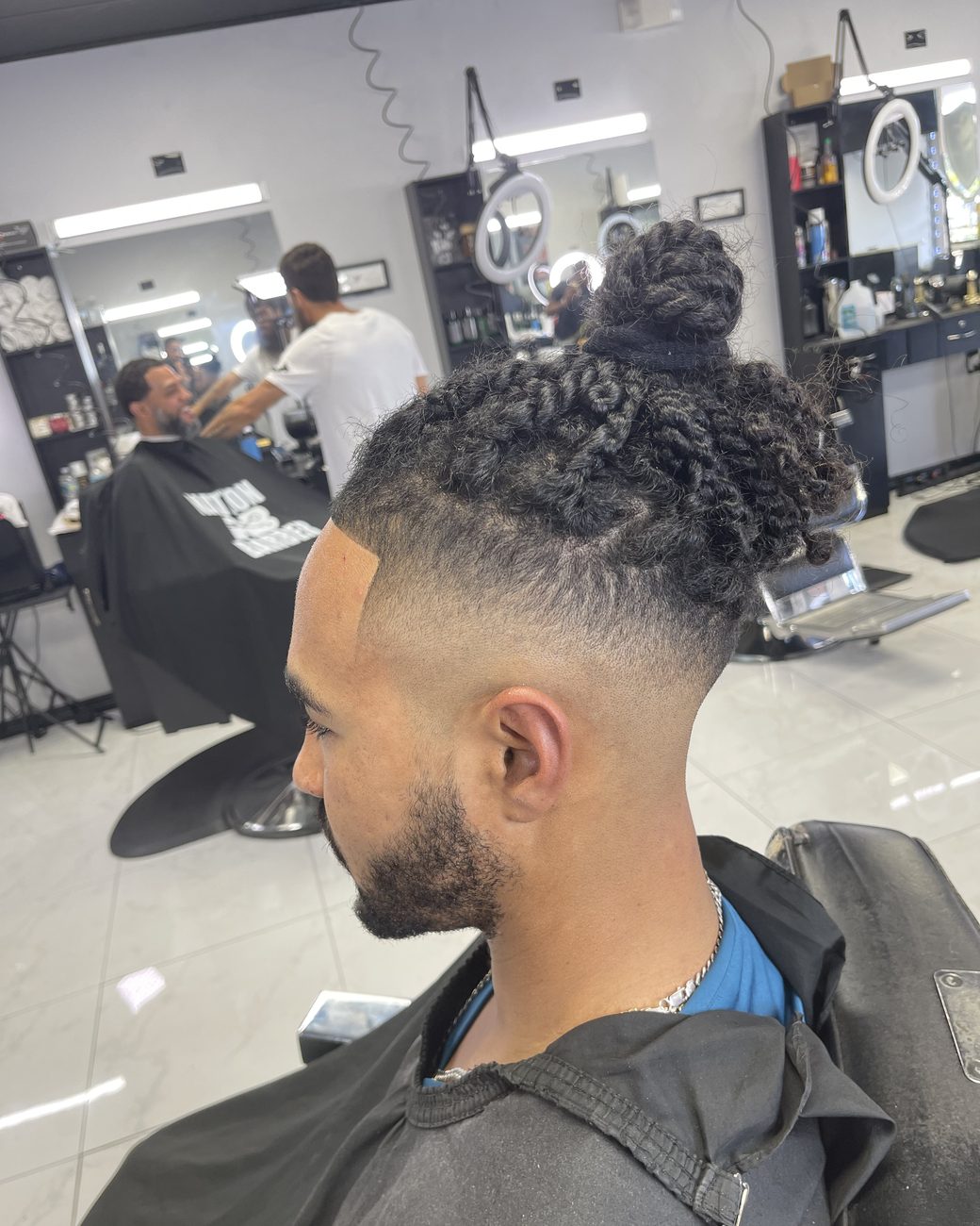 Curly top knot with a skin fade
