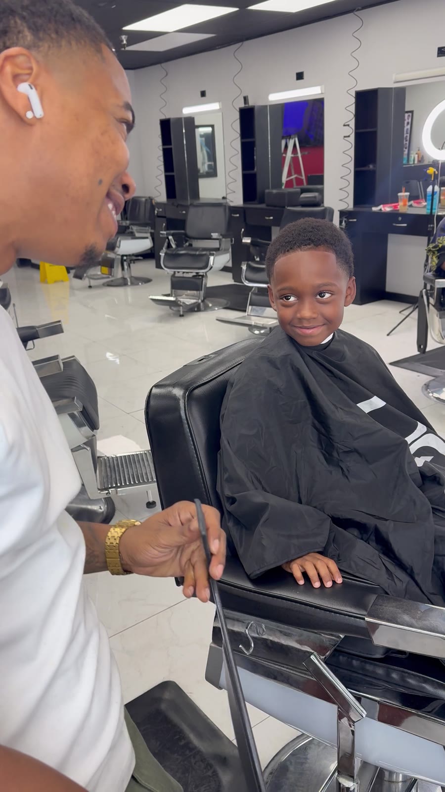 Brandon and a smiling young client in the chair